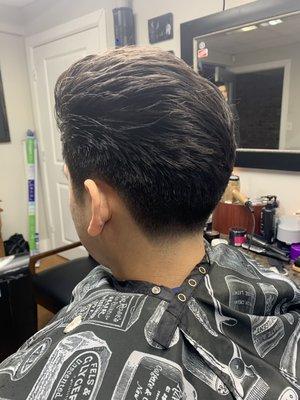 Cut with length and with ends texturized to blend the pompadour throughout.  Tapered down tight and blended with sharp hair lines.