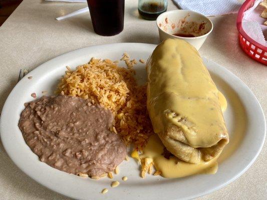 This is a chicken chimichanga served with rice and refried beans.