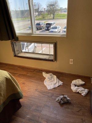 The room as we opened the door. A hole in the wall where an A/C should nave been and trash on the floor.