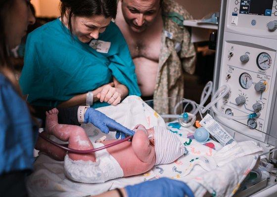 Mama and Papa meeting their baby for the first time. Sweet little one arrived via surrogacy.