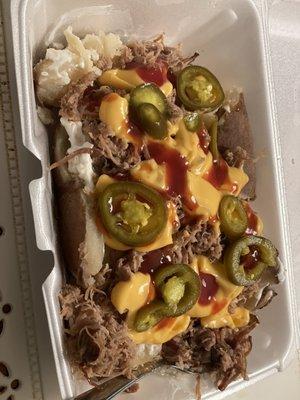 Loaded baked potato with pulled pork and mild bbq!  Love how they separated all the sides for my to go order.