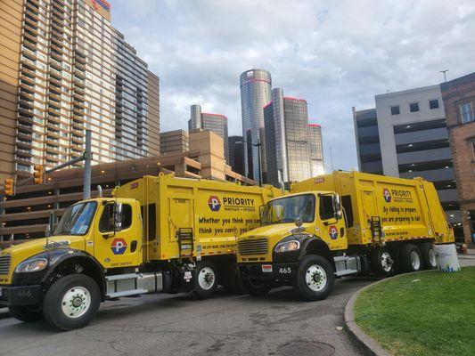 Priority Waste trucks with the Ren Cen in the background