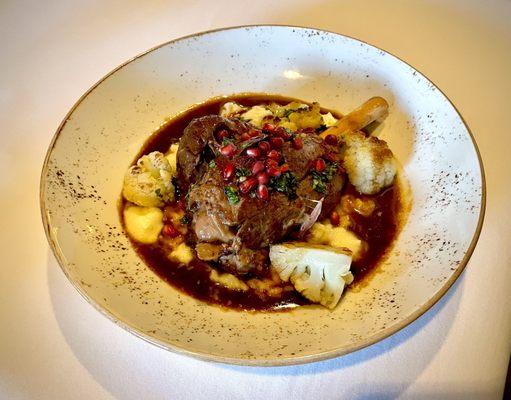 Braised lamb shank with risotto, cauliflower, and pomegranate seeds