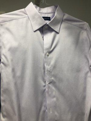 Stretched placket fabric below first button, wrinkled pressed in in the middle, generally unpressed below fourth button