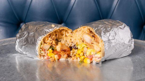 A hearty burrito packed with seasoned chicken, rice, corn, black beans, and fresh veggies, all wrapped up for a perfect, flavorful bite!