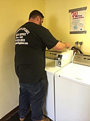 Technician DJ fixing a coin operated washer