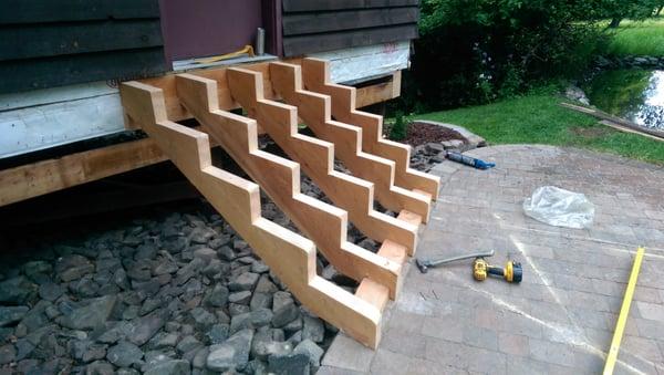 Irregular stair design.  Timber stringers that "fan out" to land on patio without taking any more space than absolutely needed.