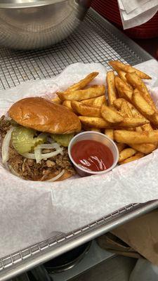 Pulled pork sandwich. (Marinated pork, onions and pickles) comes with fries