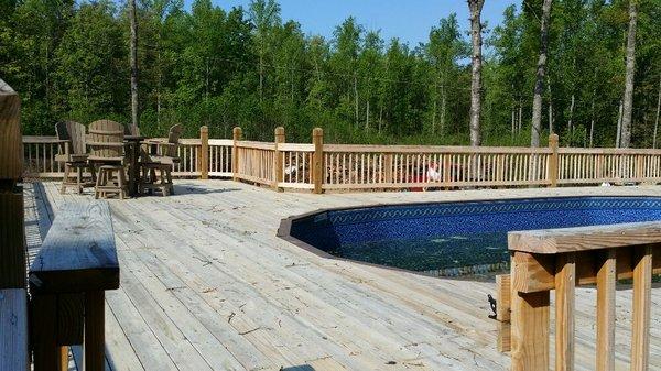 Working on stain the floor and railings in a pool area