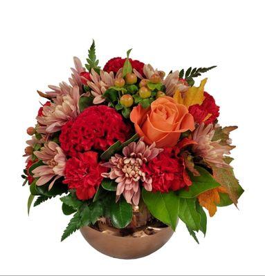 Red coxcomb and carnations with hypericums, roses and chrysanthemums in a mirrored glass vase.