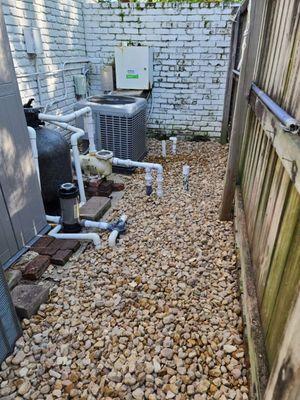 Rock installation around the AC unit and pool pump to keep the area dry, and clean.