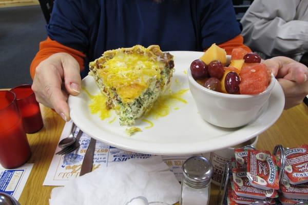 Spinach bacon quiche with a fruit cup.