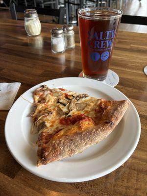 Slice of mushroom pizza with Red Trolley draft beer