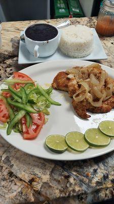 Grilled chicken, with salad and lemon. Rice and beans as a side as well