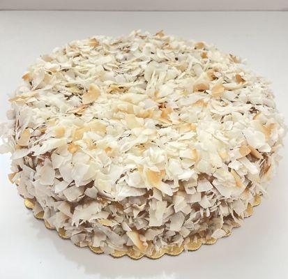 Indulge in paradise with our gluten-free, sugar-free, dairy-free Coconut Cake--rich, moist, and topped with golden coconut flakes & caramel