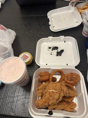 Tray with chicken strips, hushpuppies, onion rings, honey mustard sauce, and strawberry cheesecake milkshake