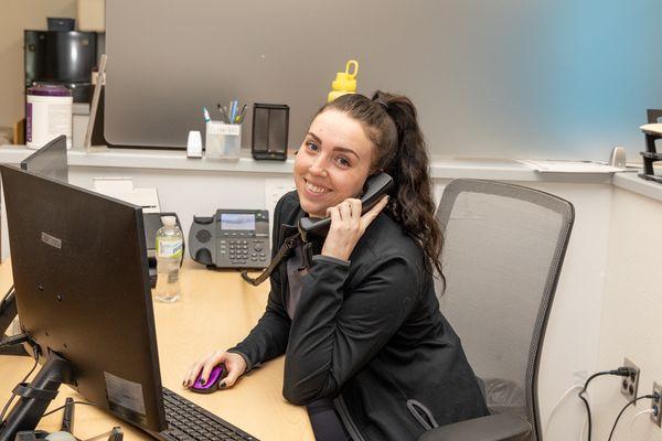 smiling front desk answering the phone