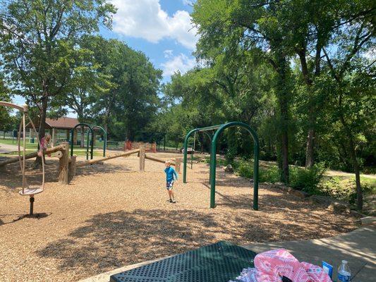 Part of the playground. A pavilion in the back ground. I feel like that merry go round has been closed for forever.