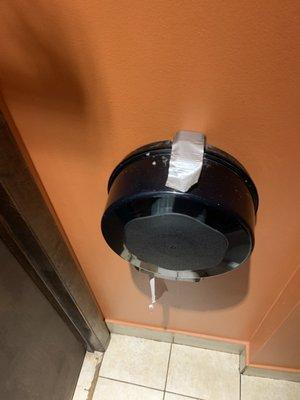 Bathroom toilet paper holder being held together by duct tape