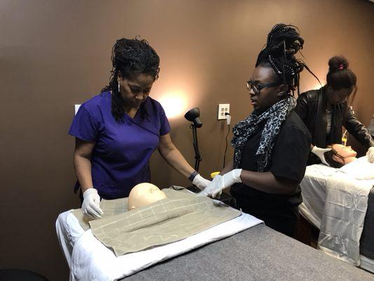 Esthetics students learning how to prepare the treatment room.