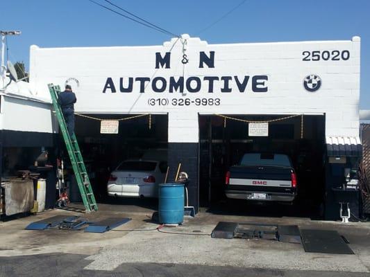 Very talented German is hand painting our storefront sign