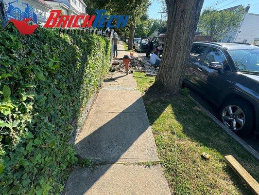 The team successfully demolished and replaced the broken sidewalk flags according to the Department of Transportation's diagram.