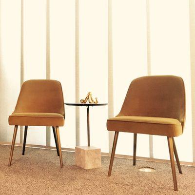 Midcentury modern chairs flanking a geometric end table.