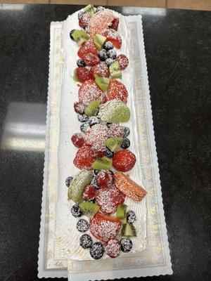 Sponge cake rolled into whipped cream with fresh berries and macarons.