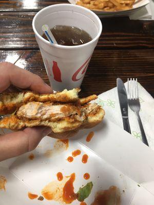 Buffalo chicken sandwich and beverage.