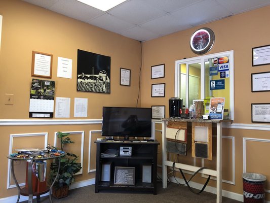 Waiting room with tv and coffee for the customers.