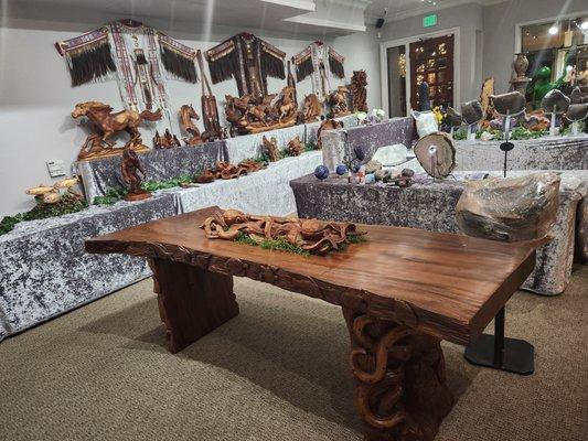 A beautifully carved live edge table with fish, shells and turtles carved on the sides with large octopus on each end base.