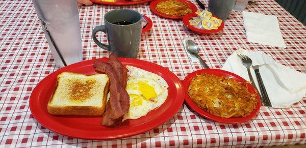 Two egg, bacon, toast with added hash browns.