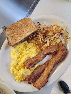 Granny's scrambled eggs, bacon, hash browns, and toast.