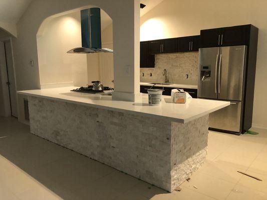 Stone veneer on backsplash and island and Quartz countertop installed by us