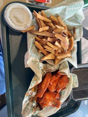 Bone in Buffalo wings with fries.