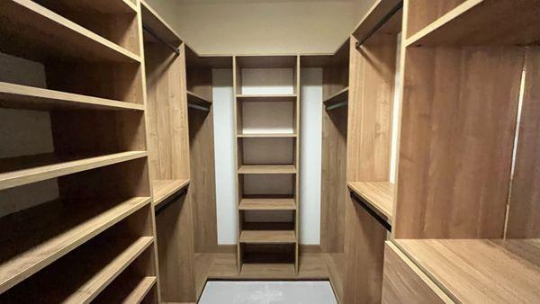 A spacious walk-in closet featuring multiple shelves organized for optimal storage and accessibility.