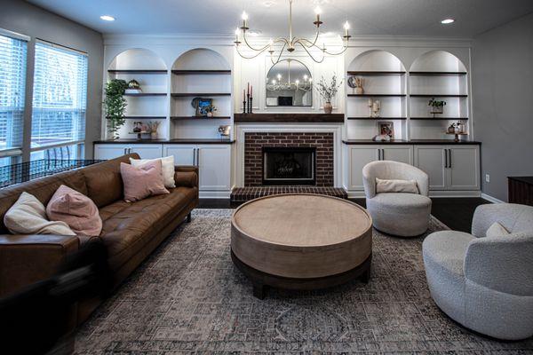 This recent project features a custom built-in fireplace surround with shaker style cabinetry and bookcases with arched valances.