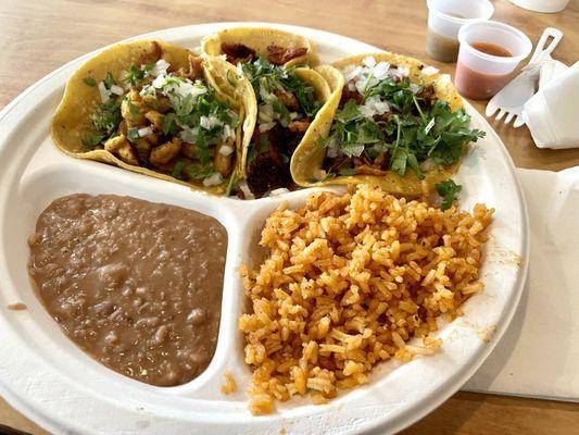 Three assorted tacos with rice and beans