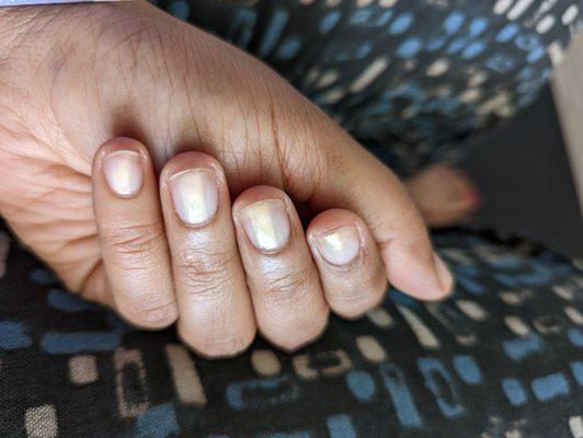 Neatly filed nails with a light nail paint that is dual colored, white with a touch of gold! My favorite!