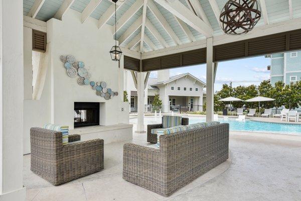 Outdoor lounge area with two padded couches and a padded sofa, adjacent to a pool at Lantower Edgewater