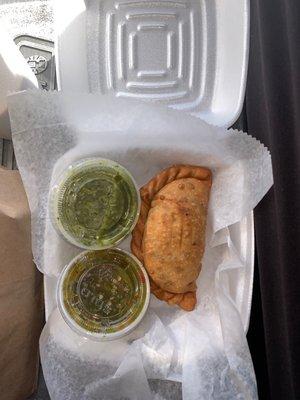 Beef Empanada Argentina with hot sauce and chimichurri sauce.