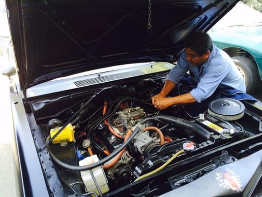 Socrates working on some throttle linkage on a 1974 Dodge Dart.