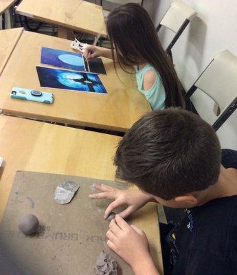 Students working in clay and oil paint.