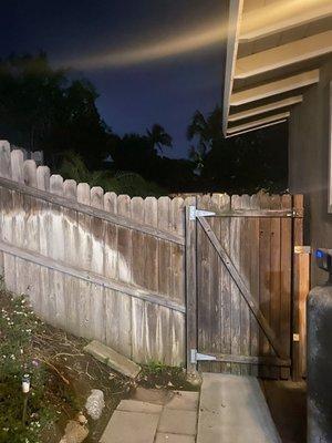 Backyard view of old wooden fence and gate that needed to be replaced.