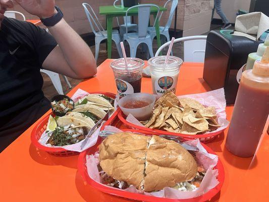 Torta de milanesa (asada), chips and salsa, tacos de al pastor, and horchata.