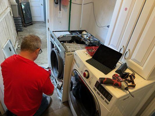 The photo shows a skilled technician from ASA Appliance Repair repairing an LG washer in Los Angeles.