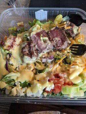 Million dollar cobb salad topped with medium rare sirloin steak