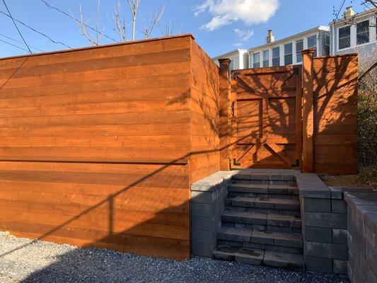 Stained Cedar horizontal fence with gate built around new Nicolock retaining wall and stairs.