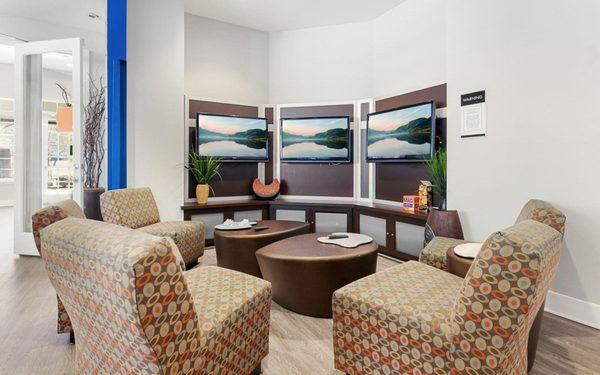 Lounge area with multiple TV screens.