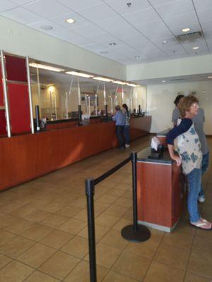 At the bank again and there's only one teller. The bank managers are too busy talking to one another.